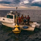 Freeboard personnel deploying a smart buoy from LimnoTech's boat in Lake Erie.